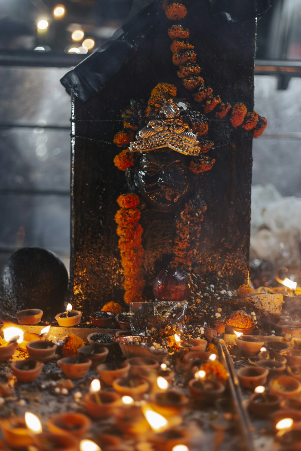 a statue of a person with a crown surrounded by candles