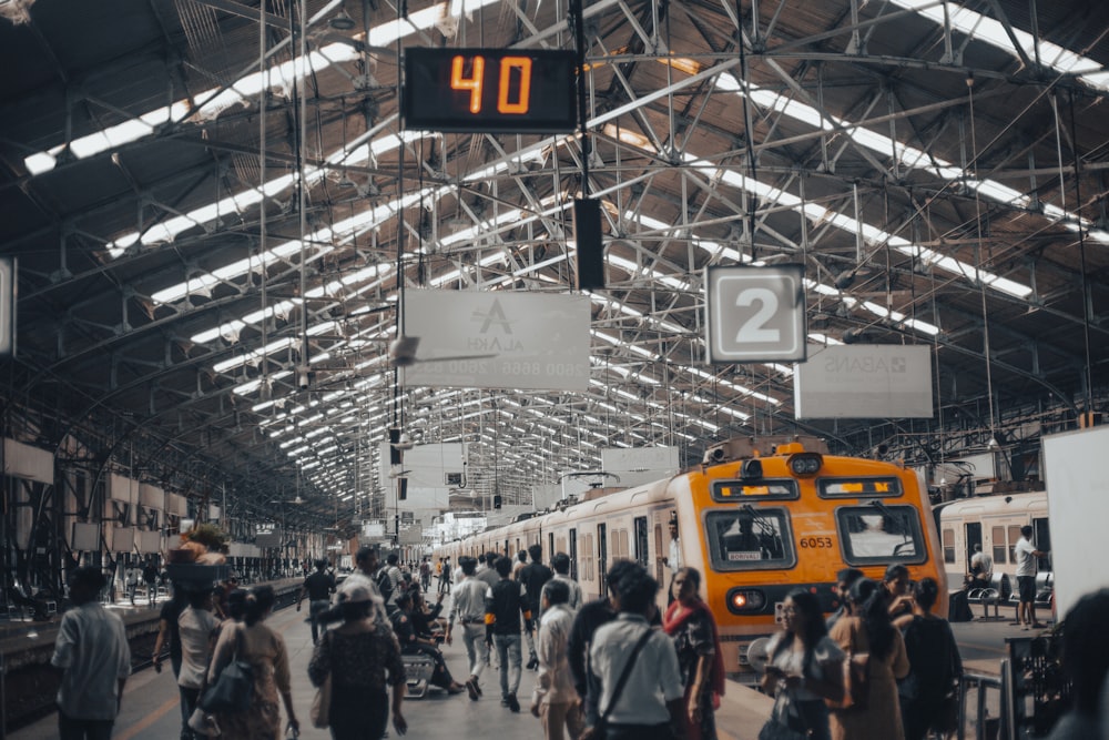 um grupo de pessoas andando em uma estação de trem