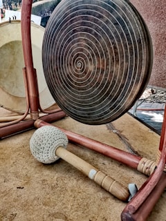 Close-up of a gong mallet striking, releasing waves of harmonic vibrations.