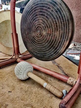 A large, shimmering gong hanging in a softly lit room, ready to create healing vibrations.