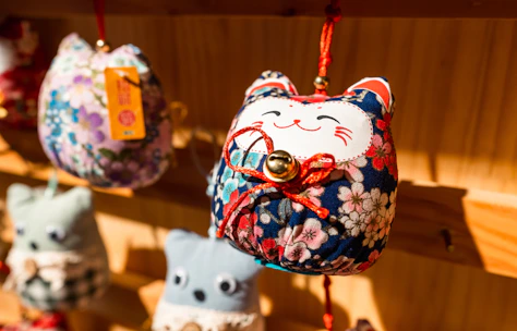 Close-up of colorful handmade cat-themed ornaments on a rustic wooden table.