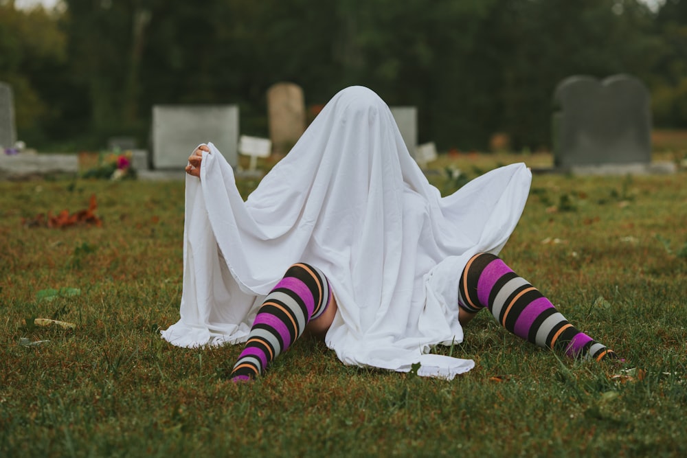a person lying on their back in a graveyard