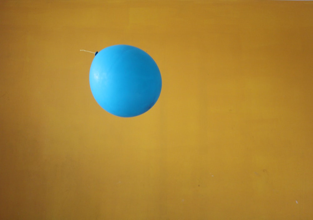 a blue balloon on a yellow background
