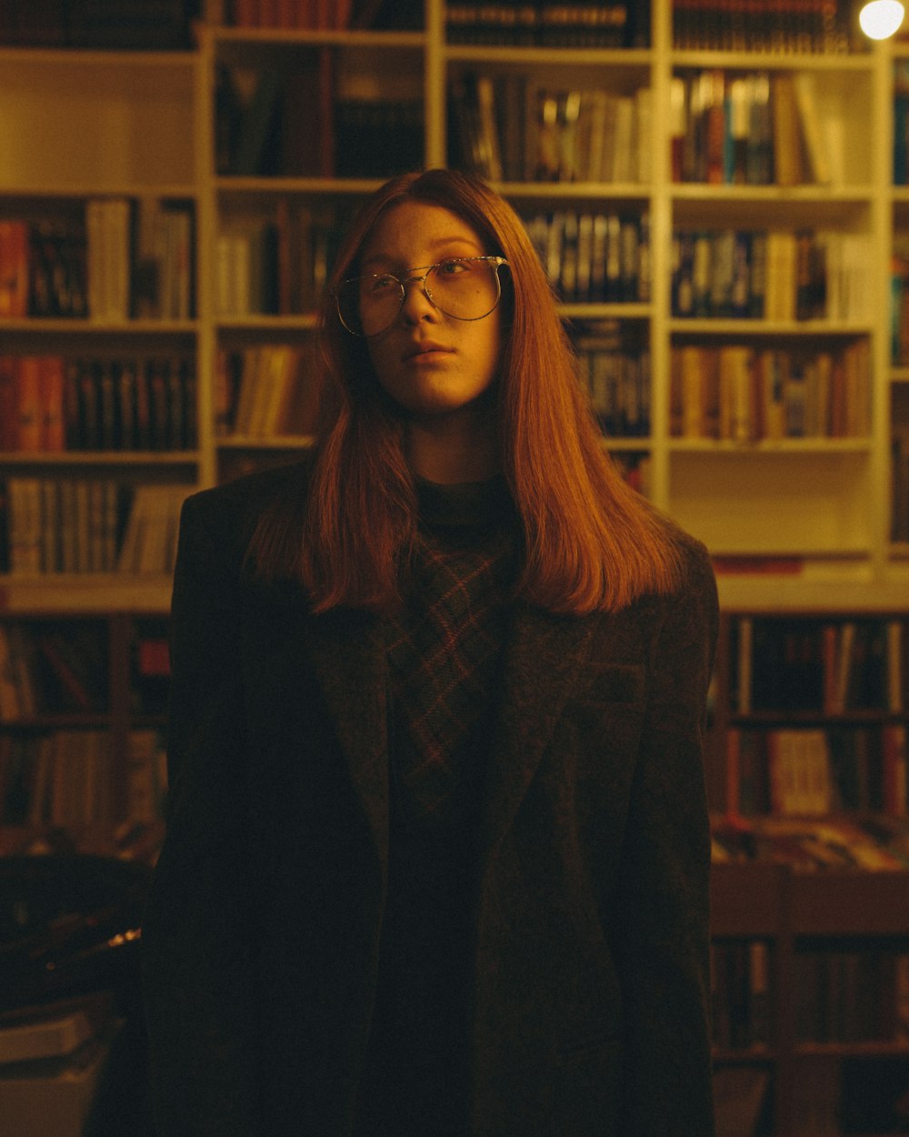 a woman standing in front of a book shelf