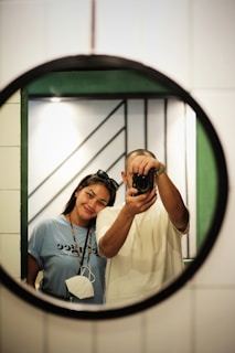 A couple taking a fun selfie using the Smilepoint photo mirror at a wedding celebration.