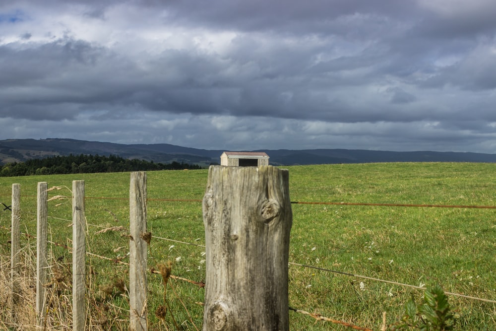 a fenced in field with a house in the distance