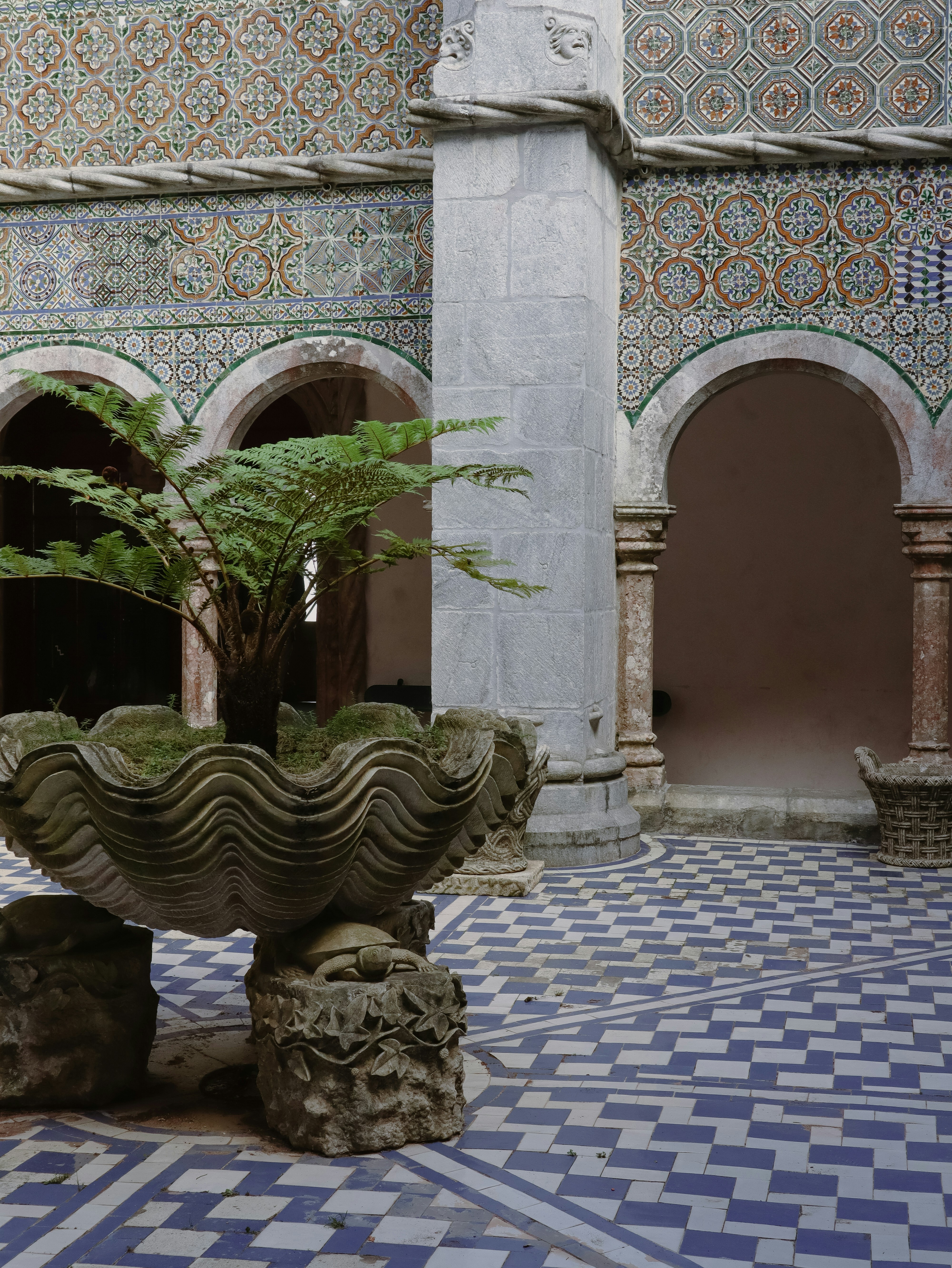a courtyard with a fountain and stone pillars