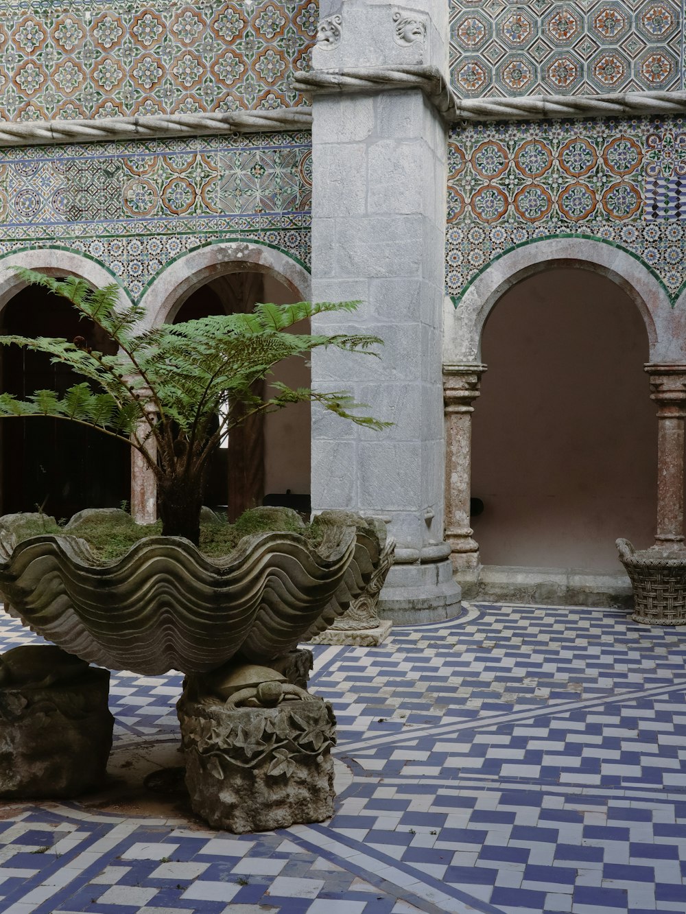 a courtyard with a fountain and stone pillars
