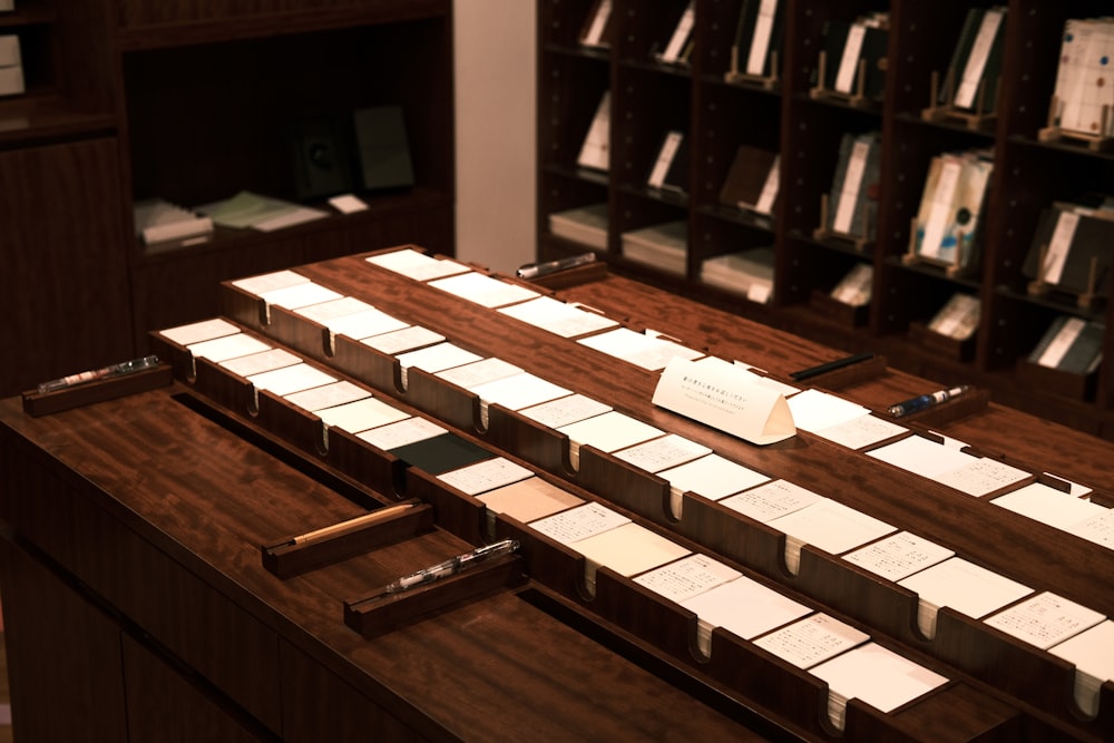 a wooden table with many pieces of paper on it