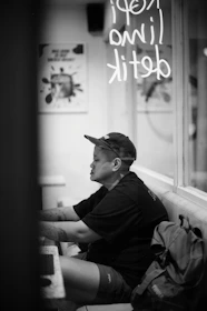A lifestyle photo of someone wearing a piercecc cap while working on a laptop at a cozy café.