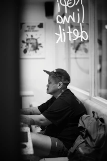 A lifestyle photo of someone wearing a piercecc cap while working on a laptop at a cozy café.