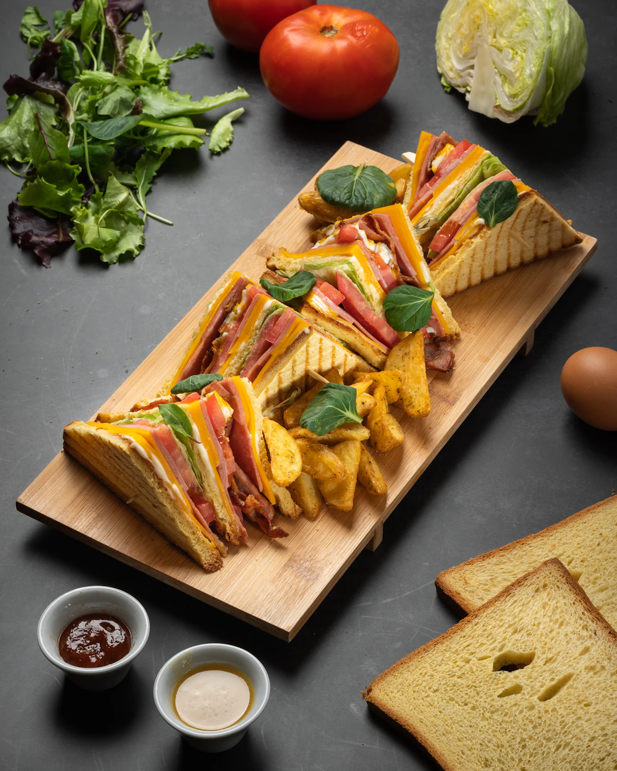 Catering platter of gourmet sandwiches on a wooden board