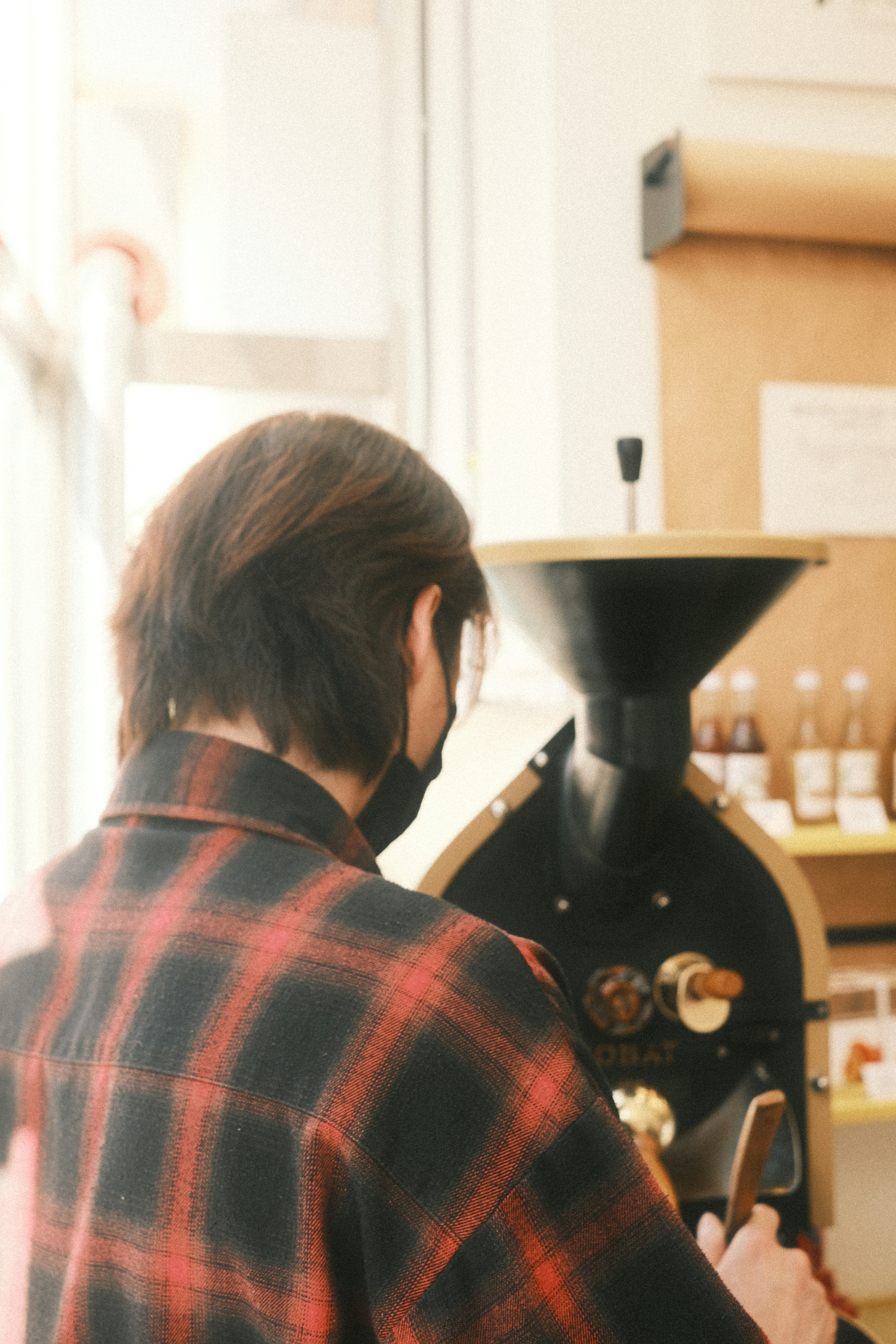 Mara at the roaster in warm natural light