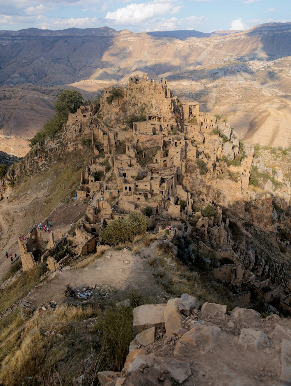 a rocky canyon with a few people climbing it