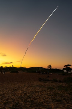 A missile launching from a submarine against a twilight sky.