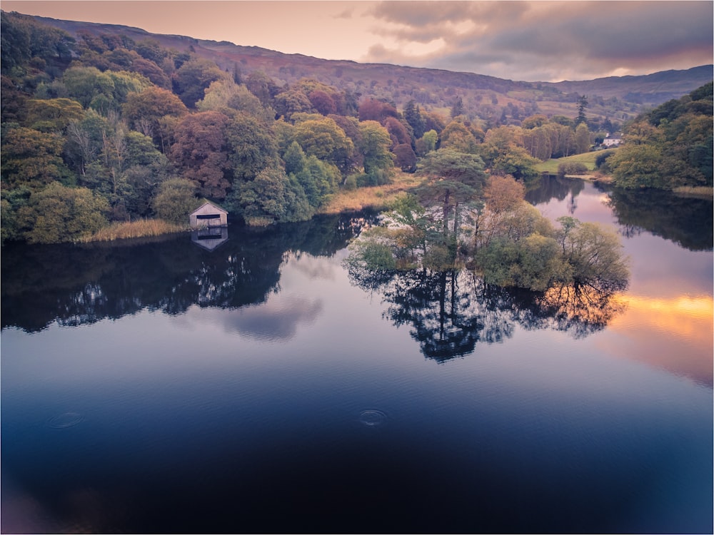 a lake surrounded by trees and hills