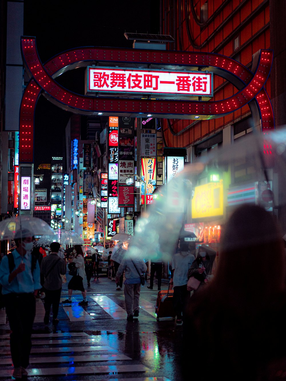 a group of people walking in a city at night