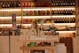 A well-stocked shop shelf filled with various beauty and wellness products, including bottles, boxes, and jars. The shelves are neatly organized with different color-coded sections containing skincare bottles, soaps, and colorful packaging. The lighting is warm and inviting.