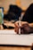 A close-up of a hand holding a sleek pen while writing on a notebook.