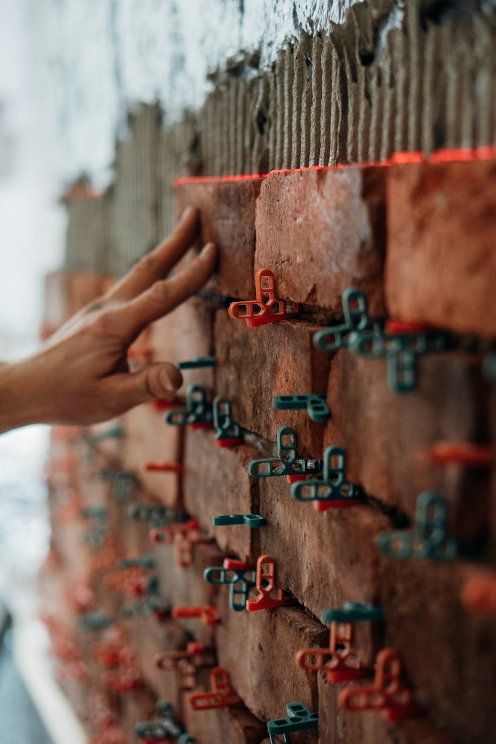 a hand reaching out to a metal fence