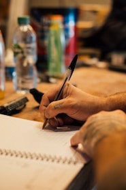 a person writing on a piece of paper