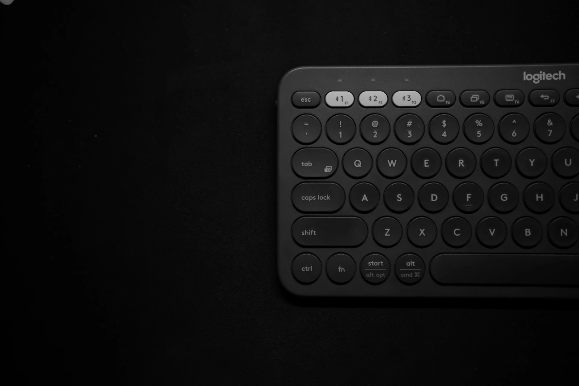 black logitech keyboard on dark surface