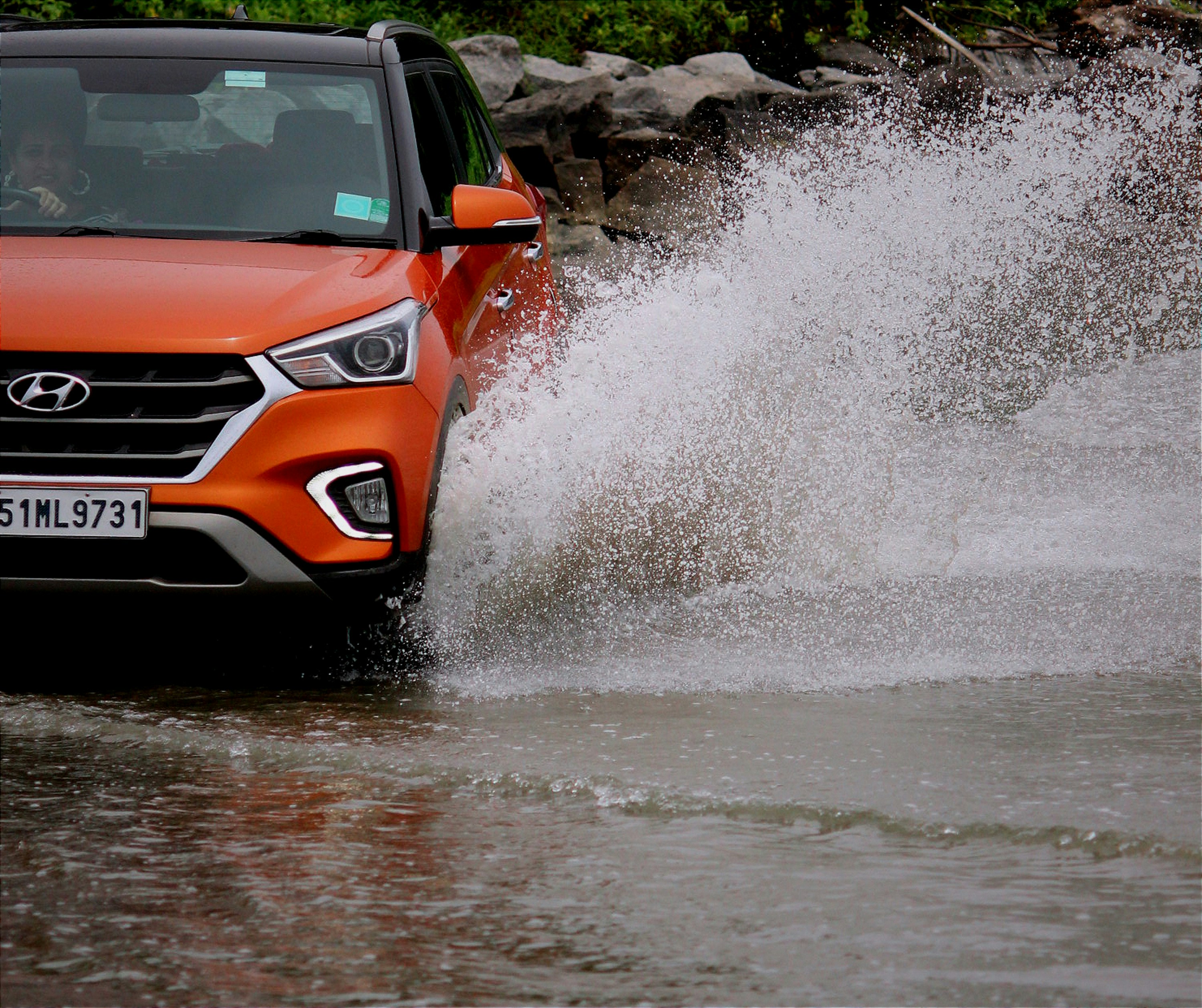 Foto Un automóvil conduciendo a través de una carretera inundada ...
