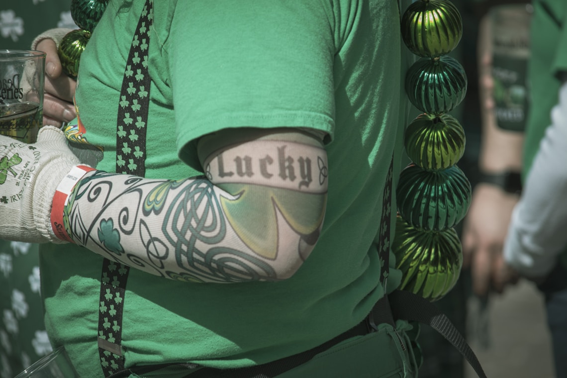 a person wearing a green shirt with a tattoo on it