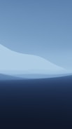 An abstract landscape featuring layered shades of blue. The composition resembles gentle waves or undulating hills, blending from dark navy to lighter sky blue tones.