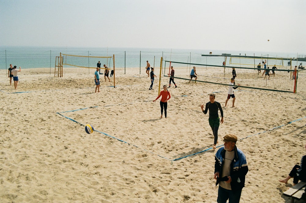 a group of people play volleyball on a beach