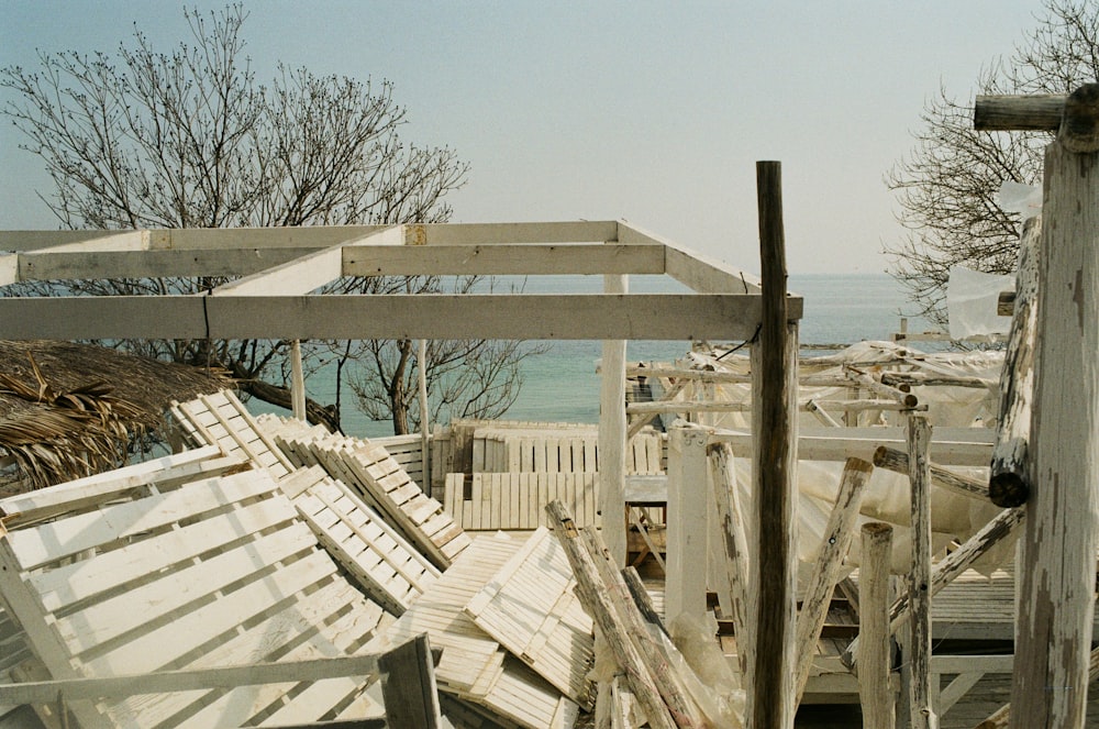 a deck with a wood railing and a body of water in the background