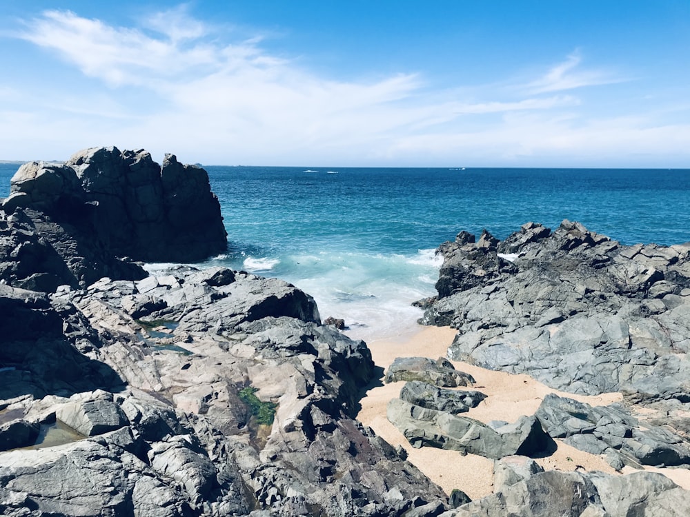 a rocky beach with water in the background