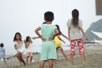 a group of children walking on a beach