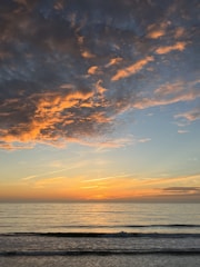 A vibrant image of a beach sunset with a travel deal pop-up graphic overlay.