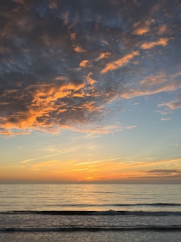 A vibrant image of a beach sunset with a travel deal pop-up graphic overlay.