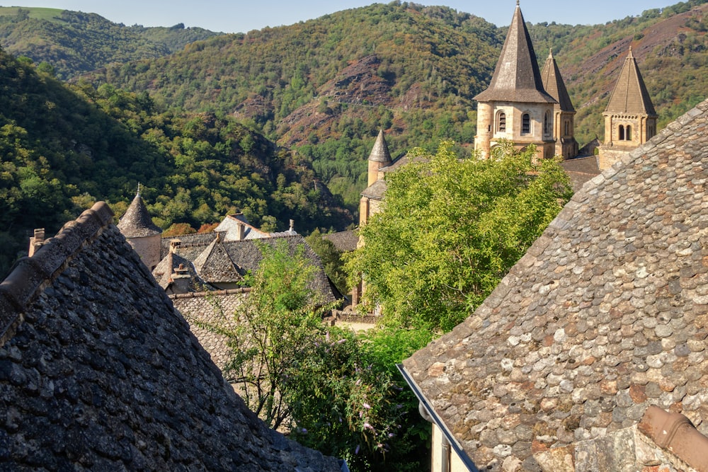 a stone wall with a building on it and trees in the back