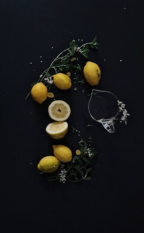 A splash of bright yellow lemons with playful faces, scattered across a clean white background.