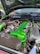 A car engine with a vibrant green valve cover and various components, including hoses and wires. The engine bay has a large, black itg air filter and shiny metallic parts. The hood is open, revealing a clean and well-organized setup.