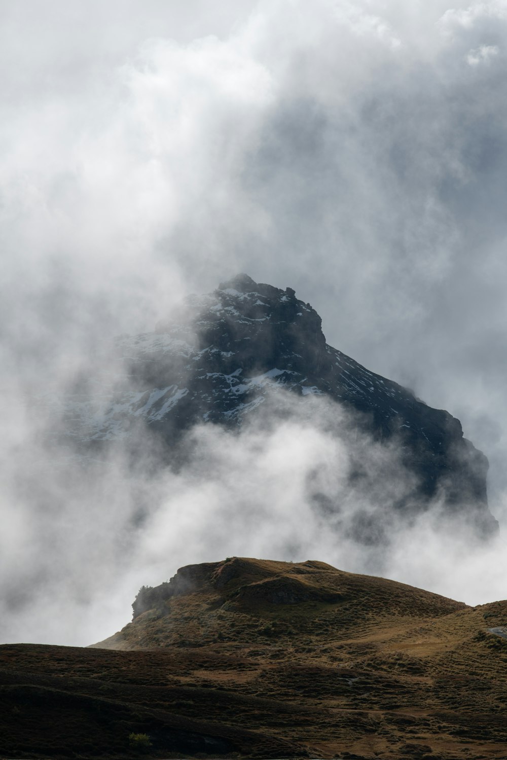 a mountain with clouds above it