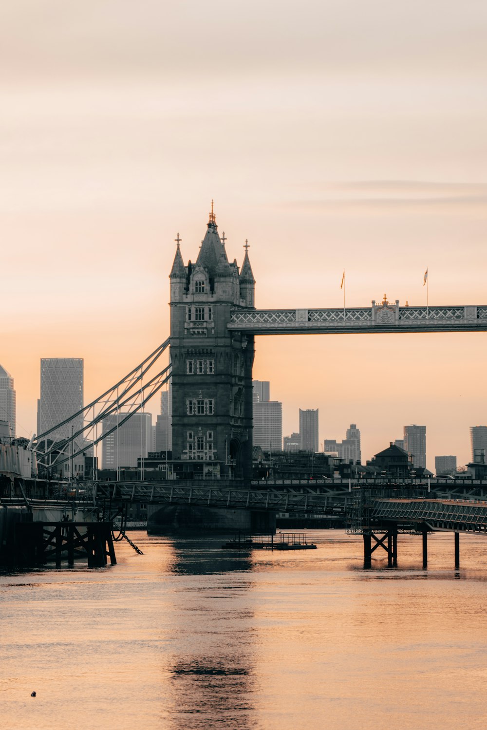 a bridge over a river with a large tower in the background