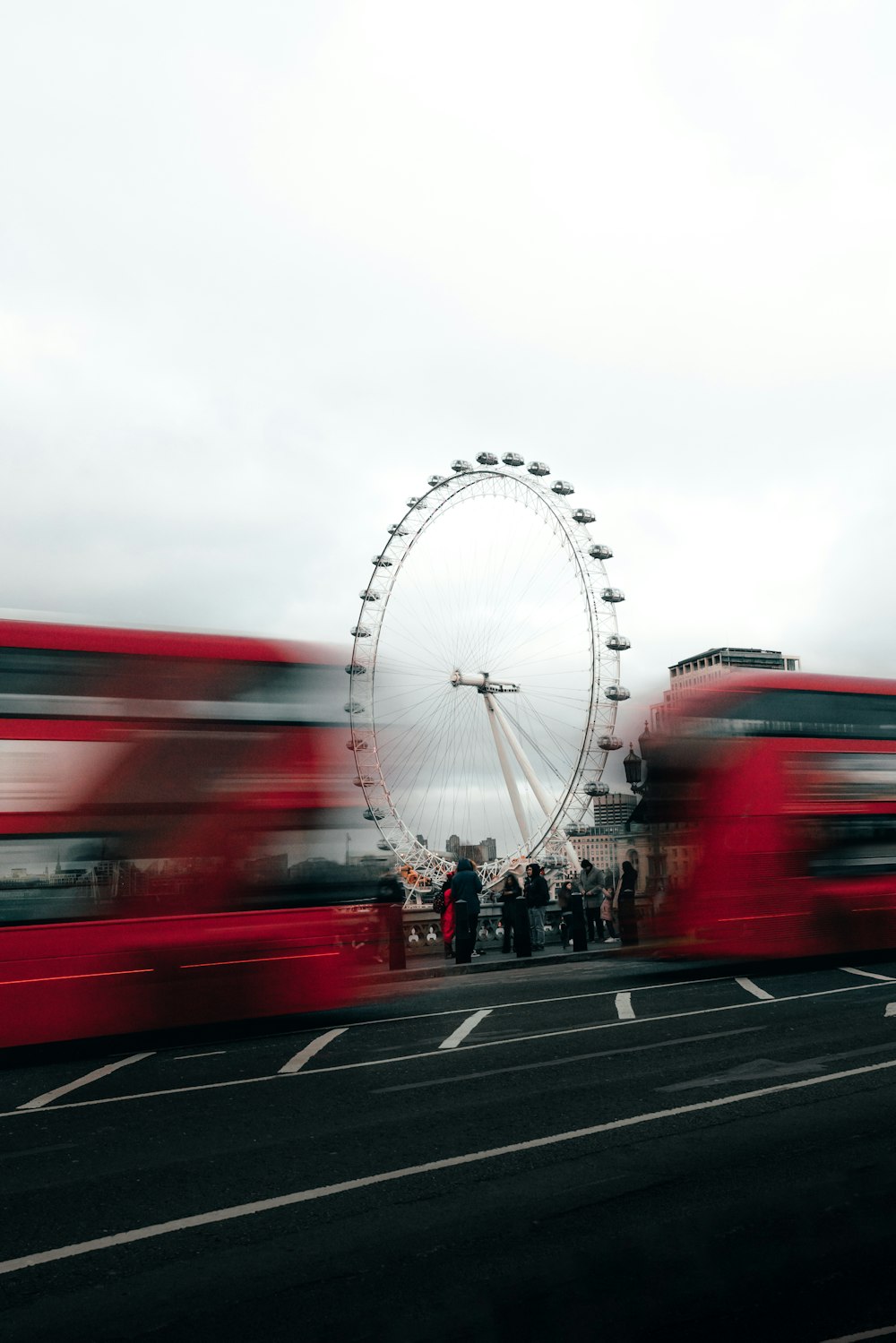 a group of people standing next to a ferris wheel