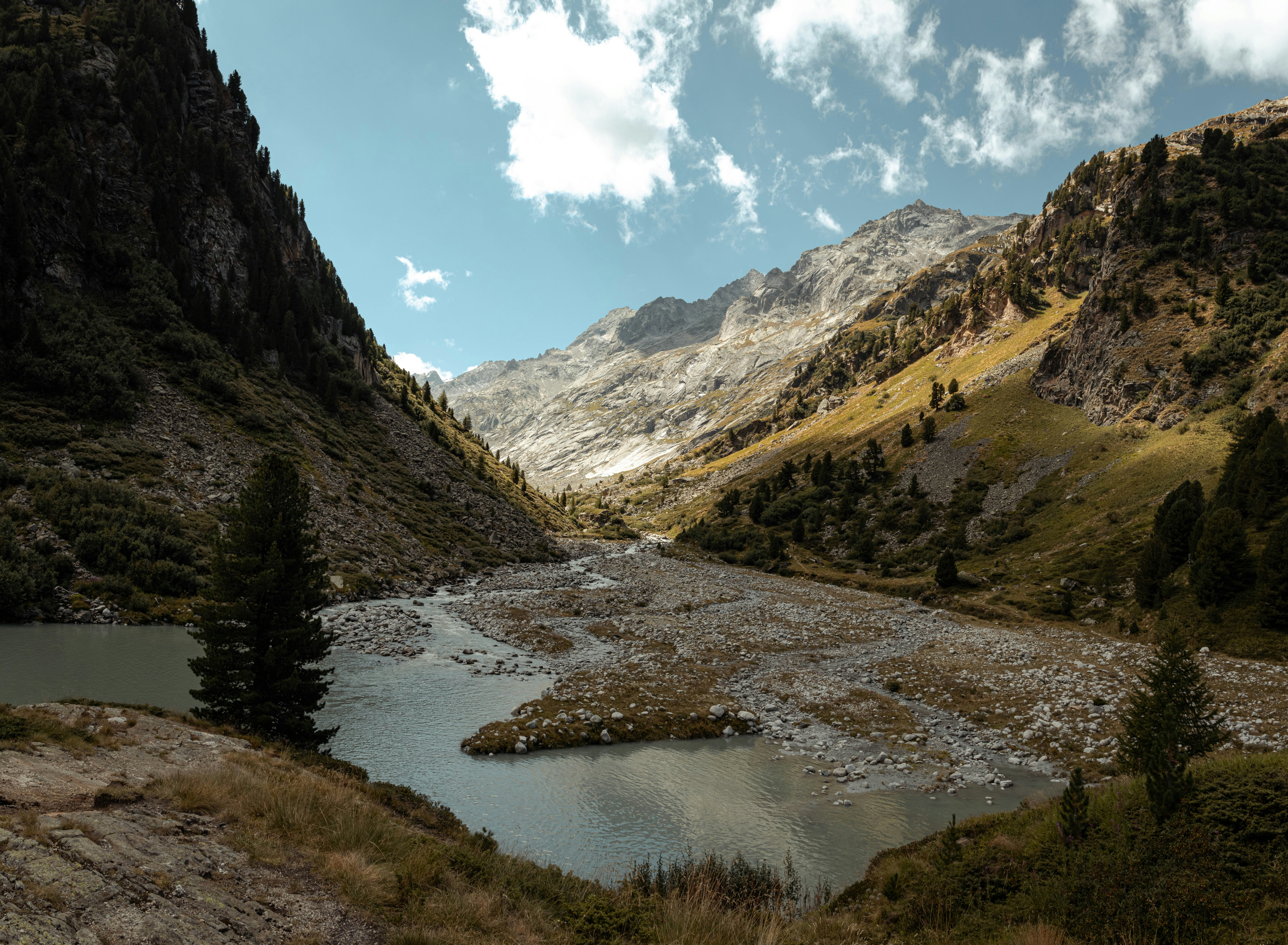 a river running through a valley between mountains
