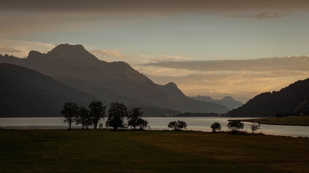 a lake with trees and mountains in the background