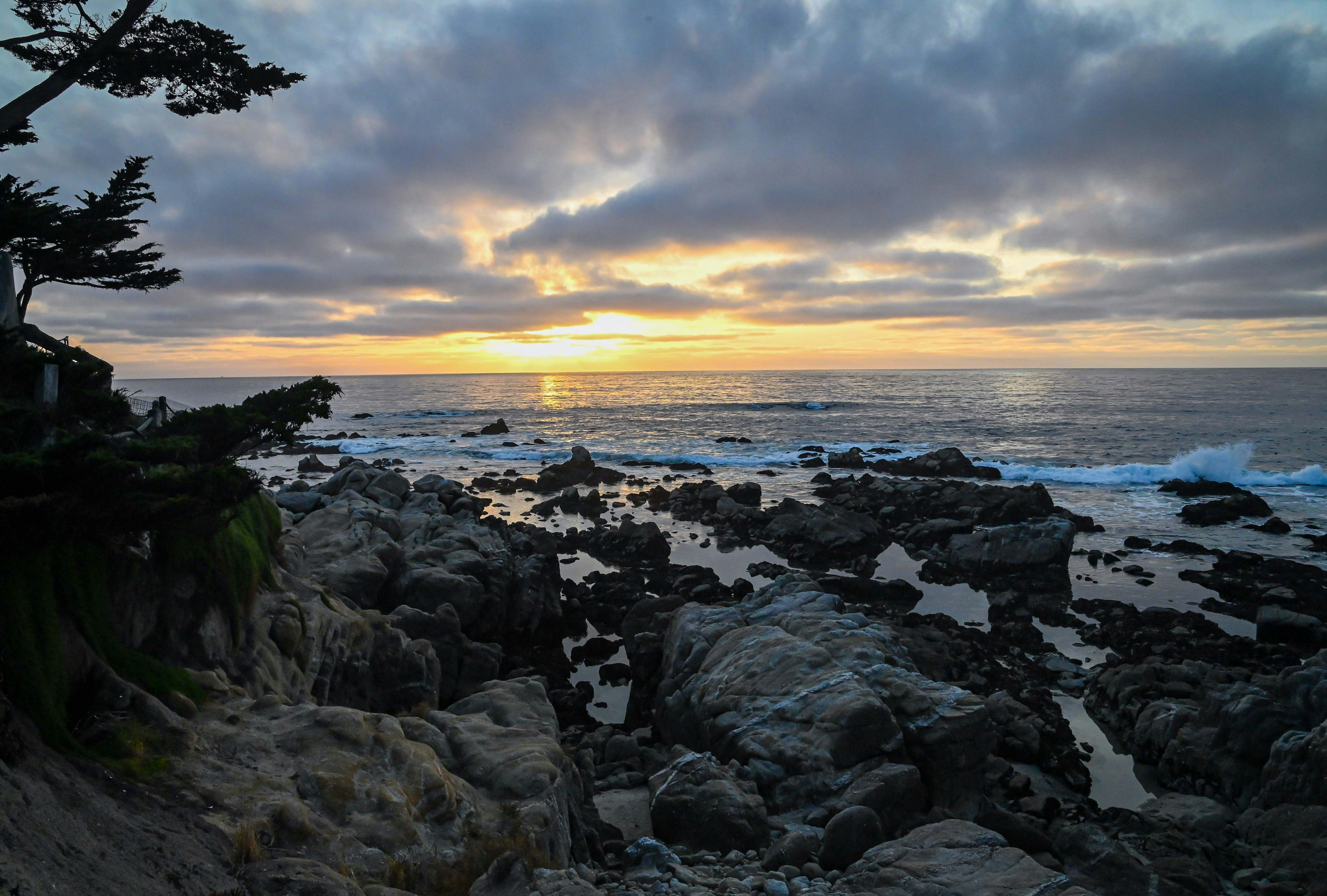 a rocky beach with a sunset, Ocean view in Carmel during sunset