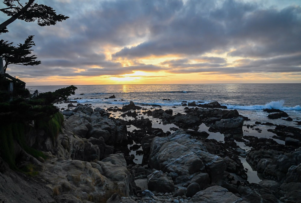 a rocky beach with a sunset