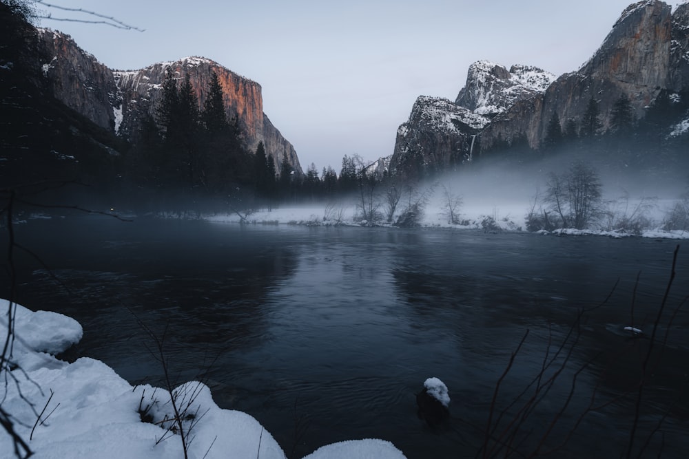 a lake surrounded by snow covered mountains