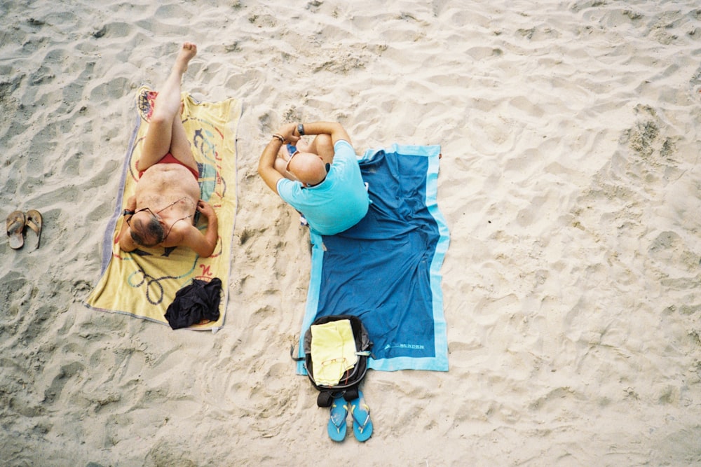 a man and woman lying on the sand