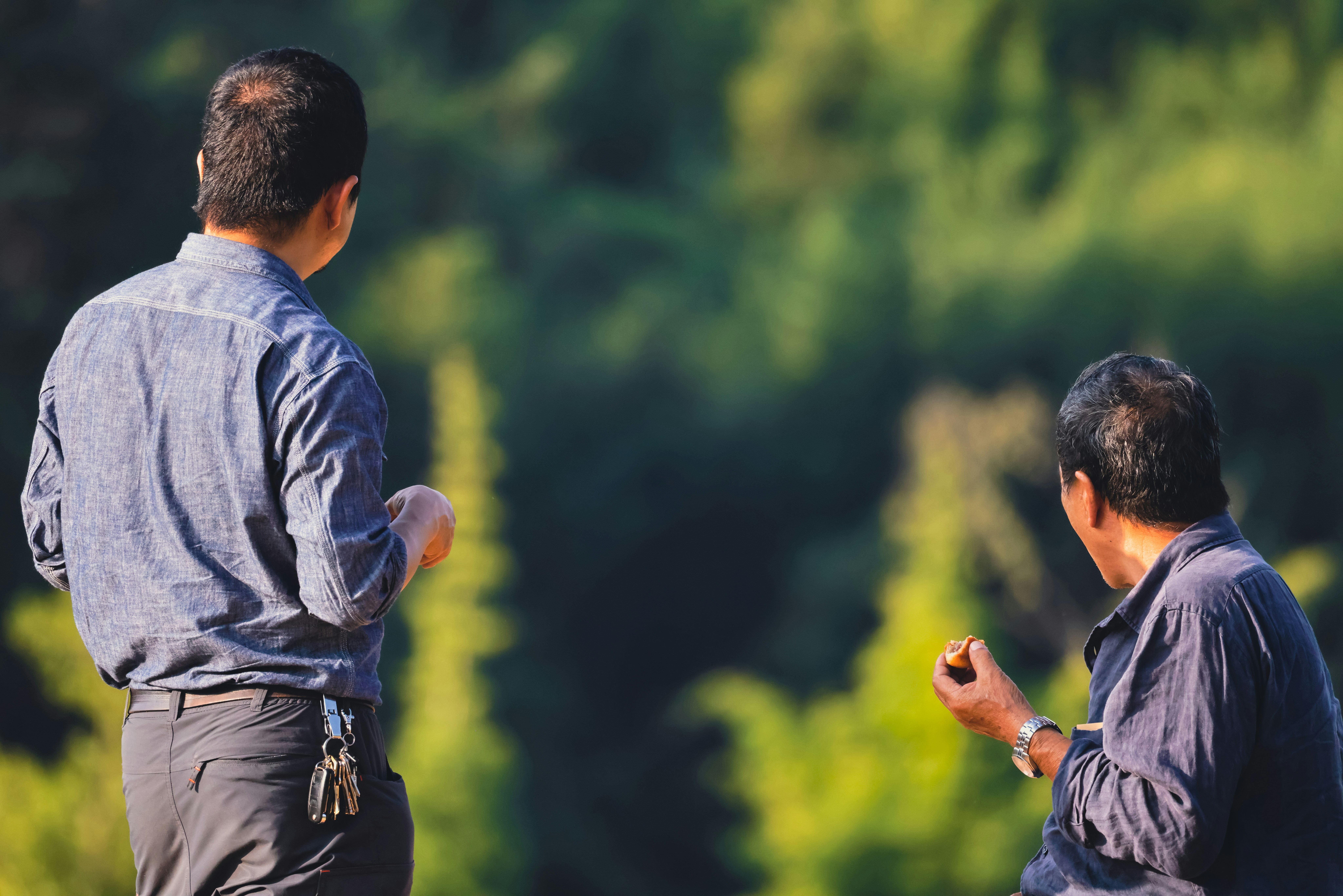 two men standing in front of a forest