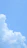 Bright blue sky with gentle rays of sunlight breaking through fluffy white clouds.