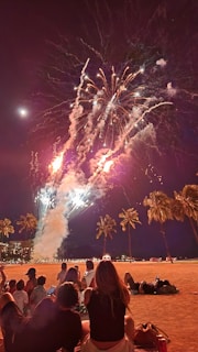 Fireworks lighting up the night sky over a beach party on the Jamaican coast.